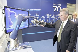 Günther Oettinger beim Handschlag mit dem SCHUNK Leich-bauarm. 