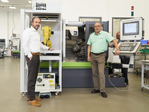 Bedienerlos produktiv: Rainer Jehle (l.), GeschÃ¤ftsfÃ¼hrer der Carl Benzinger GmbH in Pforzheim, und Dieter Wentz, Vertriebsleiter, prÃ¤sentieren das PrÃ¤zisionsdrehzentrum GoFuture BX mit der kompakten, flexibel an mehreren Maschinen im Wechsel einsetzbaren Roboterzelle 